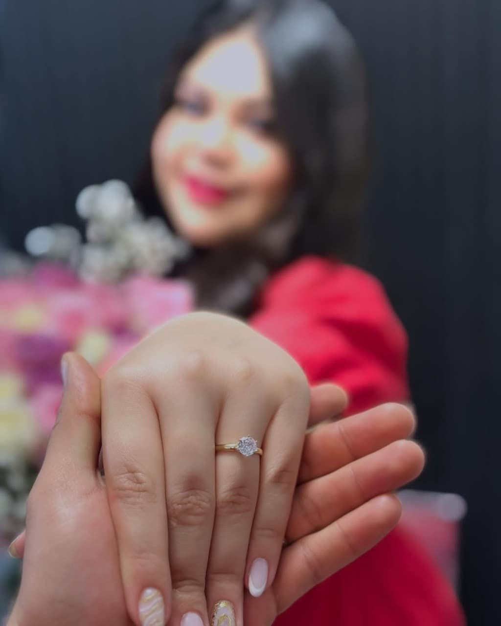 Las manos de la pareja mostrando el anillo de compromiso